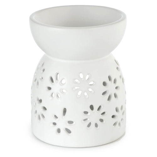 Angled view of a white ceramic oil and wax burner, featuring daisy cut-out patterns.