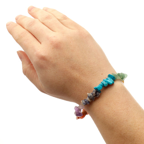 Chakra gemstone bracelet with colorful irregular stones worn on a wrist, lifestyle shot.