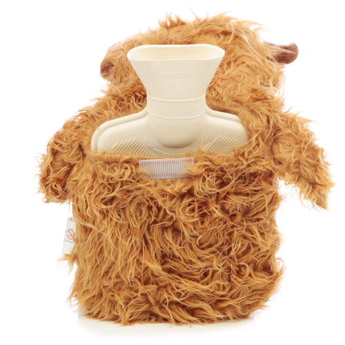 Elevated view of a Highland Coo cow hot water bottle, featuring a shaggy ginger plush cover and the cream rubber bottle's exposed neck. A dark ear and white tag are visible on the cover.
