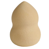 Upright light beige makeup beauty blender applicator sponge, with an hourglass shape featuring a pointed tip and rounded base, on a white background.