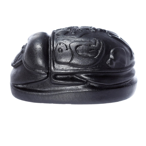 Side view of a Decorative Black Egyptian Scarab Ornament with carved patterns on its back.