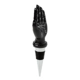 Front view of a black hand novelty bottle stopper with white palmistry and zodiac symbols, above a silver and black rubber stopper.