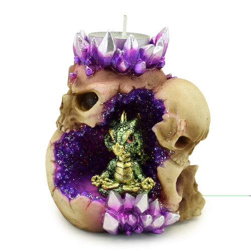 Front view of a skull cave tea light holder with purple crystal formations, a green baby dragon figurine inside, and a silver tea light candle.