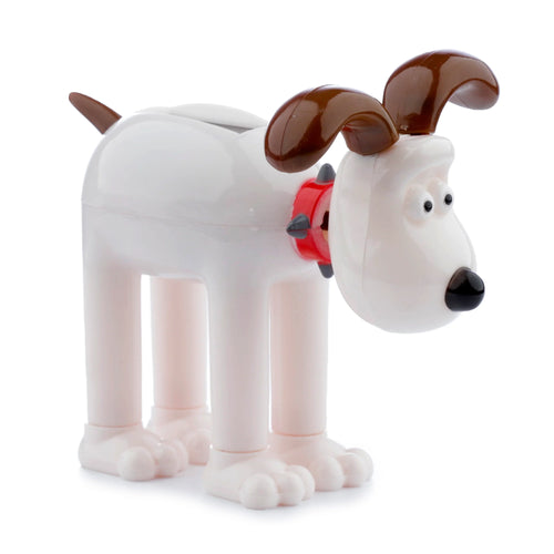 Angled view of a collectable licensed Gromit solar pal figurine, featuring its cream-coloured body, brown ears and tail, red spiked collar, and solar panel on its head.