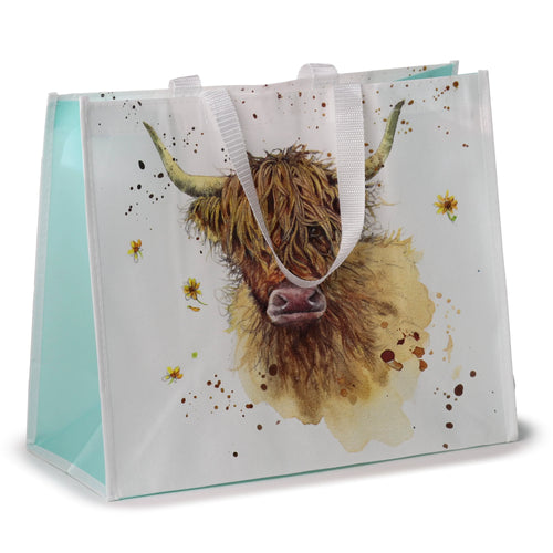 Angled front view of a reusable shopping bag, white with light teal sides, featuring a large watercolour illustration of a Highland Coo. The design includes yellow flowers and brown splatters, with white woven handles.