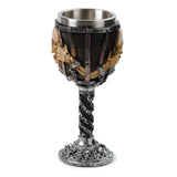 Decorative goblet with a textured dark grey and silver finish, featuring light-coloured skull heads and skeletal hands seemingly breaking through vertical bars on the cup. The twisted stem is wrapped with silver chains, and the round base is adorned with small skulls and chains. Full view.