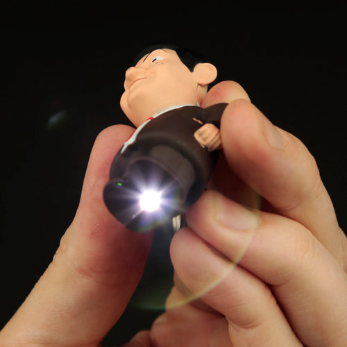 Mr Bean LED keyring figure held in hands, featuring his iconic face, brown suit, and a bright LED light shining from its base.