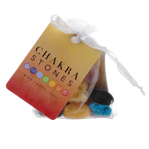 Front view of a white mesh bag containing a set of seven colourful chakra stones, with a red and yellow gradient tag displaying 'CHAKRA STONES' text and chakra symbols, secured by a white ribbon.