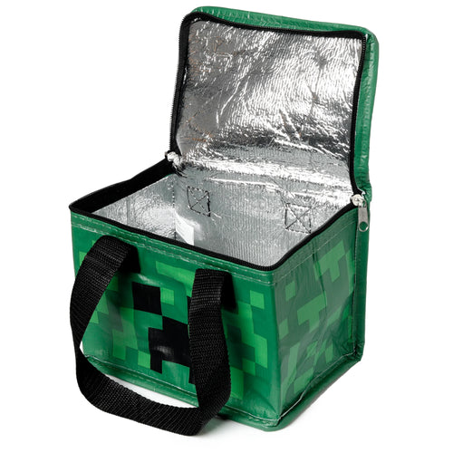 Angled view of an open green Minecraft Creeper cool bag, displaying its silver insulated interior, black zip, and black carry handles.