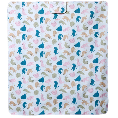 Overhead view of a white picnic blanket featuring a repeating pattern of playful cats in pink, blue, beige, and olive green.