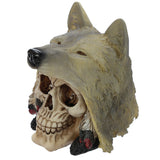 Angled view of a fantasy skull and wolf head figurine ornament, featuring a bone-coloured skull emerging from a textured, greyish-tan wolf's head with a black nose, pointed ears, and red and black feather details.