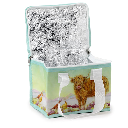 Open Highland Coo cow cool bag, angled to show its silver insulated interior. The bag's exterior features a vibrant illustration of a shaggy brown Highland cow and grouse on a heather landscape, with white webbing handles and a mint green base trim.