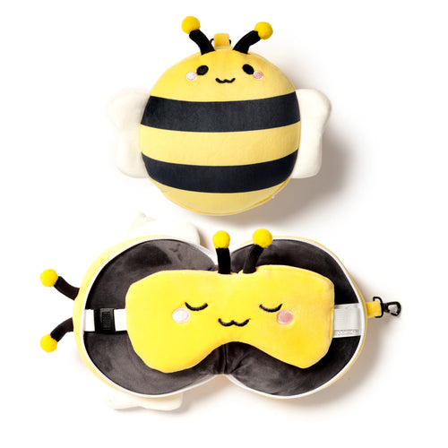 Overhead view of a yellow and black striped plush bee travel pillow and eye mask set, showing the compact bee pillow and the unzipped pillow revealing the matching eye mask.