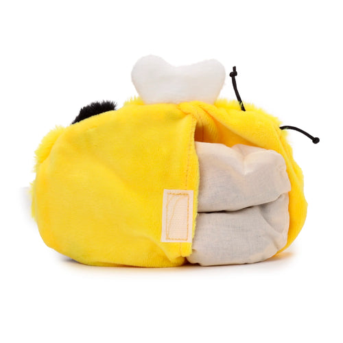 Angled view of a yellow plush bumble bee heat pack, with its soft outer layer pulled open to reveal a light-coloured internal heat pack. A white hook-and-loop fastener, black antennae, and white wings are visible.
