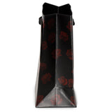 Side view of a small black gift bag featuring a repeating red rose pattern.