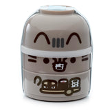 Front view of a round, taupe Pusheen the Cat stacked bento lunch box, featuring character art of Pusheen and food designs, secured with a light blue elastic strap.
