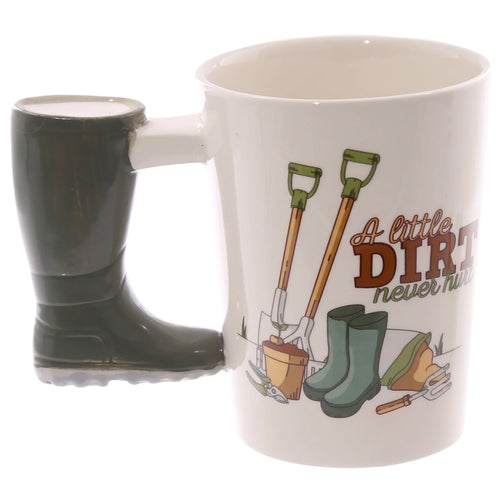 Angled view of a cream ceramic mug with a dark green Wellington boot-shaped handle. The mug features a garden illustration depicting spades, green wellington boots, gardening tools, and the phrase 'A little DIRT never hurt'.