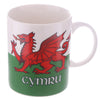 Angled view of a collectable porcelain mug featuring a bold red Welsh dragon design on a white background, with a lower green band displaying 'Cymru' text.