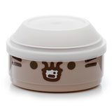 Angled front view of a round, light brown Bento lunch box with a translucent white lid, featuring a dark brown Pusheen the Cat face design with eyes and whiskers.