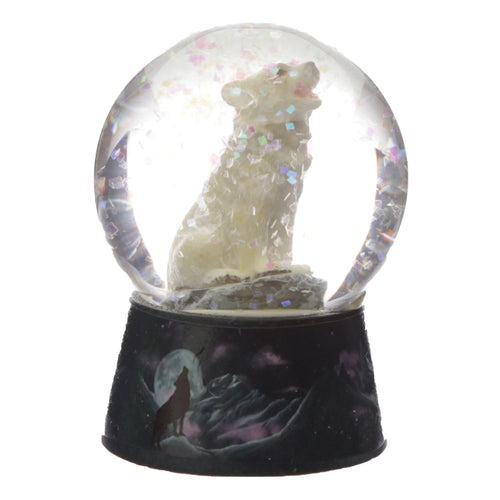 Front view of a snow globe featuring a white wolf howling inside, surrounded by iridescent square glitter. The dark base depicts a silhouetted wolf howling at a full moon above mountains under a purple-tinged sky.