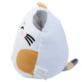 Angled view of Lola the Cat plush toy. The soft white, ginger, and grey cat features embroidered black eyes, a pink nose, whiskers, a grey ear, a striped tail, and a visible care label on its side.