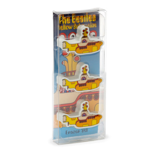 Angled view of three yellow submarine erasers, presented in a clear plastic pack, with their colourful details visible. The packaging features text reading 'The Beatles Yellow Submarine' and 'Eraser Set' on the blue backing card.