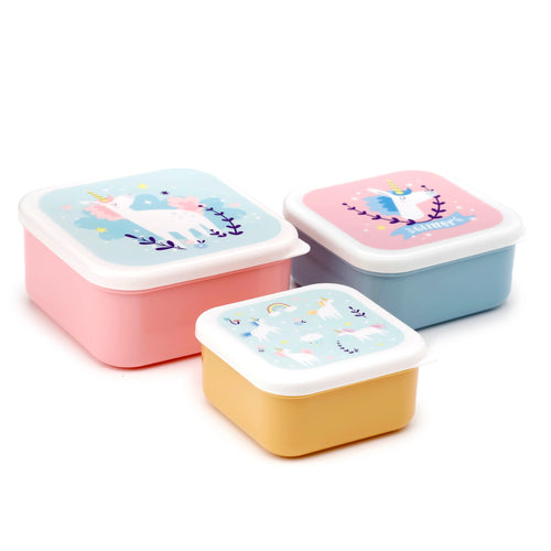 Angled view of a set of three rectangular lunch boxes (S/M/L). The boxes have pastel pink, light blue, and yellow bases with white lids adorned with colourful unicorn and star designs.