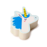 Angled top-down view of a blue and white unicorn head eraser with a yellow horn and pink cheek, on a white background.