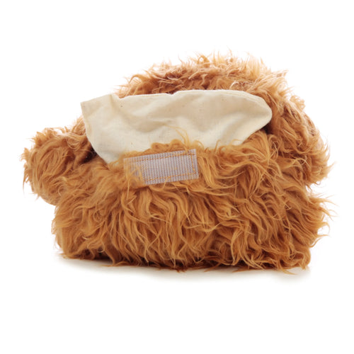 Angled view of a Highland Coo Cow heat pack, showing its shaggy brown fur and the beige fabric access flap for the microwavable wheat insert.