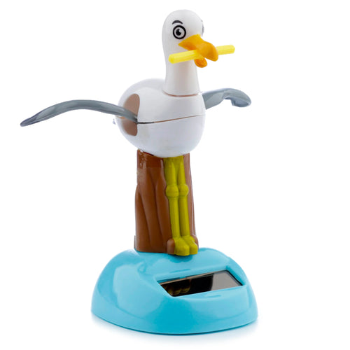 Front view of a white collectible solar powered seagull pal toy with grey wings, yellow beak holding a fry, and a blue base featuring a solar panel.