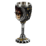 Decorative Steampunk skull goblet, showing a brown-hatted skull with goggles, grey and brass-coloured gears, screw-thread stem, and metal lining.