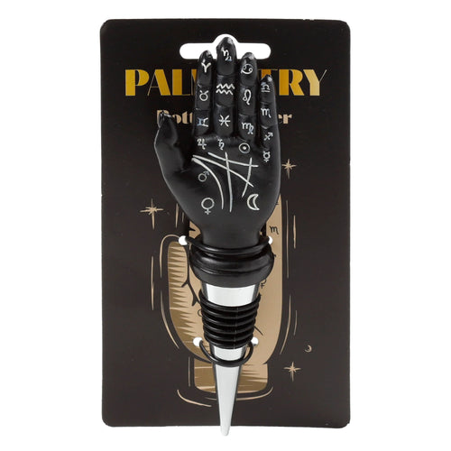 Front view of a novelty black palmistry hand bottle stopper with white astrological symbols, featuring a silver and black rubber base, displayed on black retail packaging.