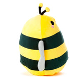 Angled view of a yellow and dark green striped plush bee toy, featuring a black eye, pink blush, yellow antennae, and a silver wing, against a white background.