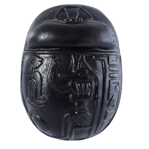 Front view of a decorative black Egyptian scarab ornament with carved details on a white background.