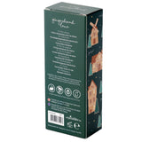Angled view of a dark green rectangular moisturising hand cream box, featuring 'gingerbread lane' text, ingredient details, and icons for cruelty-free, palm oil free, vegan, and moisturising on its front panel. The visible side is decorated with a festive pattern of gingerbread houses, windmills, and Christmas trees.