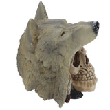 Angled view of a textured greyish-brown fantasy wolf head ornament with a black nose, depicted over a bone-coloured skull.