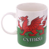 Front view of a white porcelain mug featuring a red Welsh dragon on a white and green Welsh flag design, with 'CYMRU' text.
