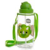 Angled studio shot of a clear children's water bottle with a bright green cartoon Triceratops dinosaur graphic. It features a matching green spout lid, internal straw, and an adjustable green fabric carrying strap.