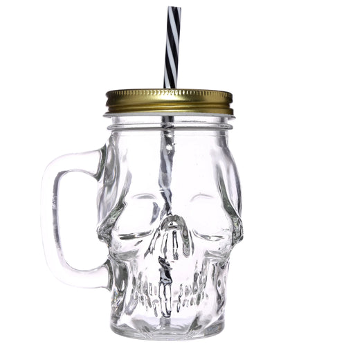 Front view of a clear glass skull-shaped drinking jar with a gold lid and a black and white striped straw.