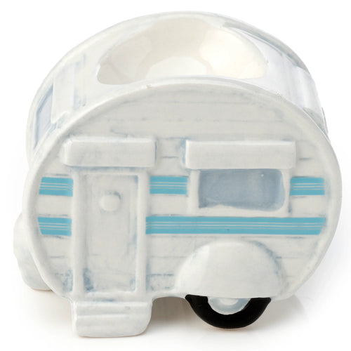 Side view of a white ceramic egg cup shaped like a caravan, featuring light blue stripes, a door, windows, and a black wheel.