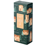 Angled view of a dark green Christmas Gingerbread Lane hand cream box, prominently displaying Gingerbread Moisturising Hand Cream 75ml on the front panel. The box is decorated with illustrations of gingerbread houses, pine trees, and falling snowflakes, alongside festive greetings in various languages.