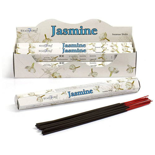 Angled display of jasmine incense stick packs in a white cardboard box, with one hexagonal pack and several black incense sticks with red ends laid out on a white background.